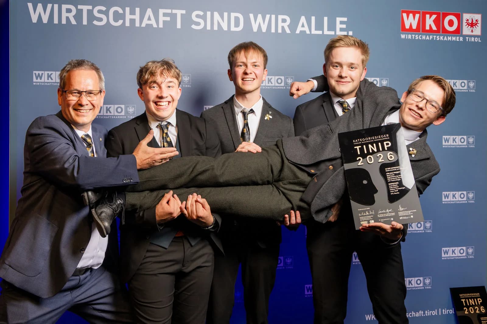 Das BeeTronic-Team mit der Urkunde des Tiroler Nachwuchs-Ingenieurpreises TINIP 2026 vor der Fotowand der Wirtschaftskammer Tirol